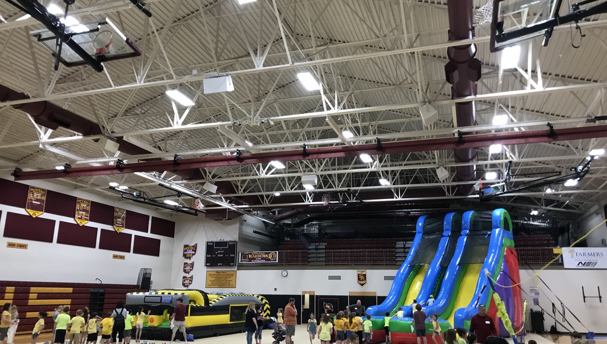 Inflatable slides set up in a school gymnasium