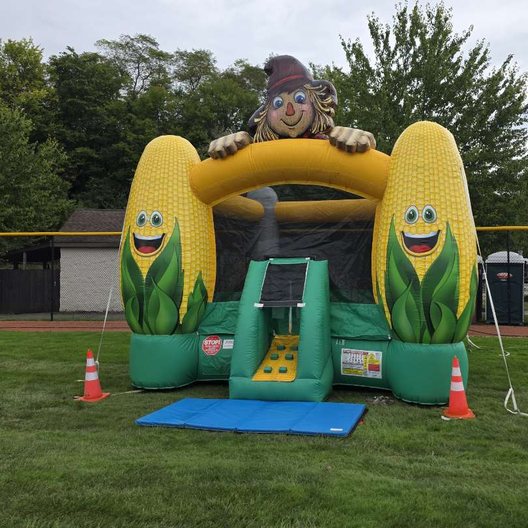 Corn-themed bounce house set up for a fall festival