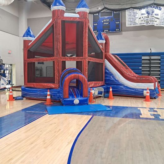 Castle bounce house with a slide set up for a party