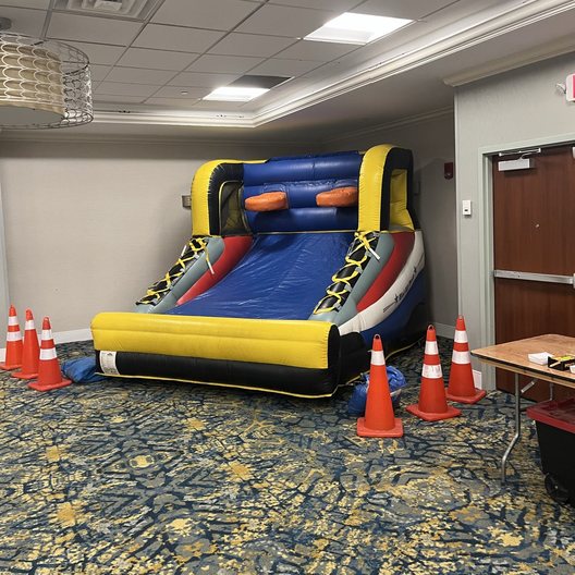 Inflatable slide set up in a carpeted event hall